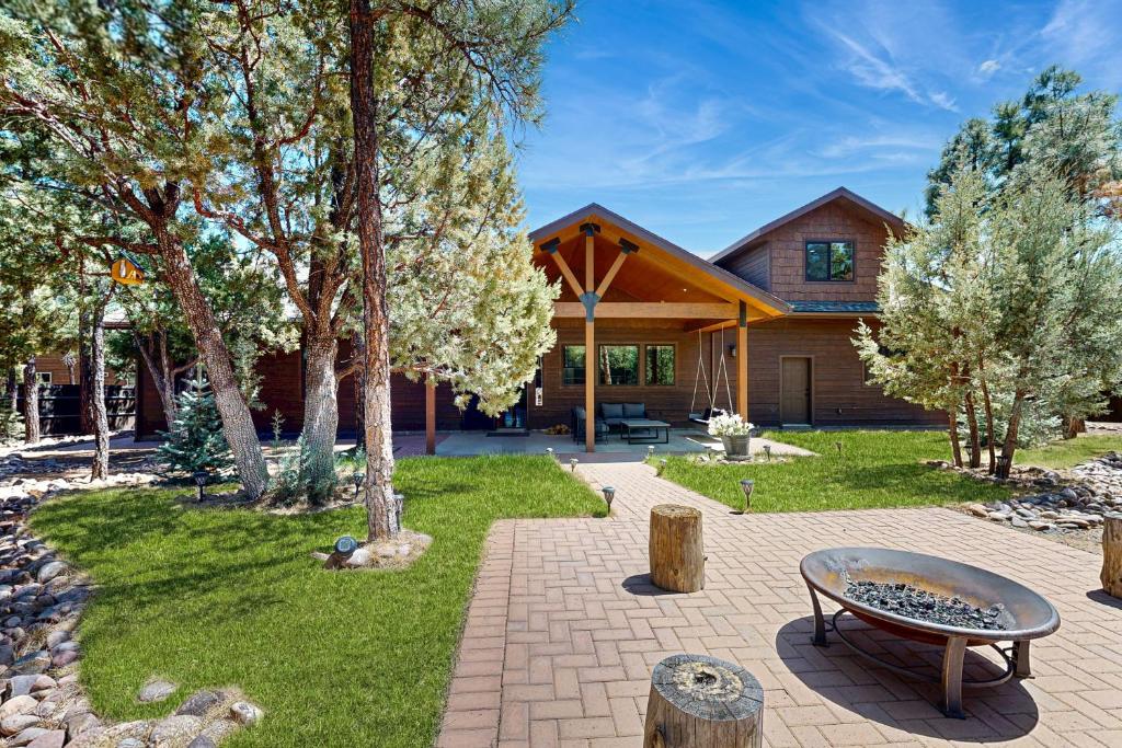 una casa con un patio con un banco y árboles en Modern Mountain Luxury Retreat, en Show Low