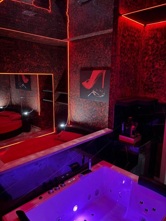 a room with a tub in a room with red lights at L'H LION's RED SUITE in Castrovillari