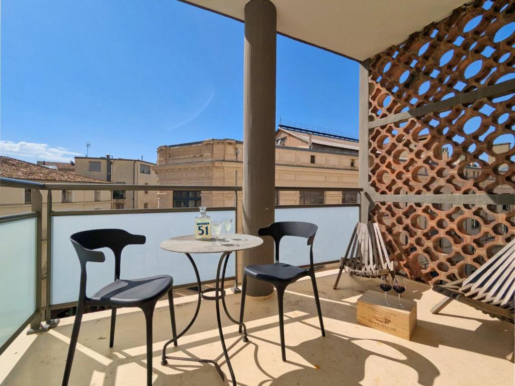 un patio avec une table et des chaises sur un balcon dans l'établissement L'authentique - Hyper centre - Belle terrasse !, à Béziers