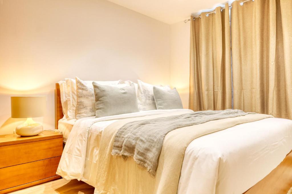 ein Schlafzimmer mit einem Bett mit weißen Laken und einem Fenster in der Unterkunft Casa do Pinheiro II, a Home in Madeira in São Vicente