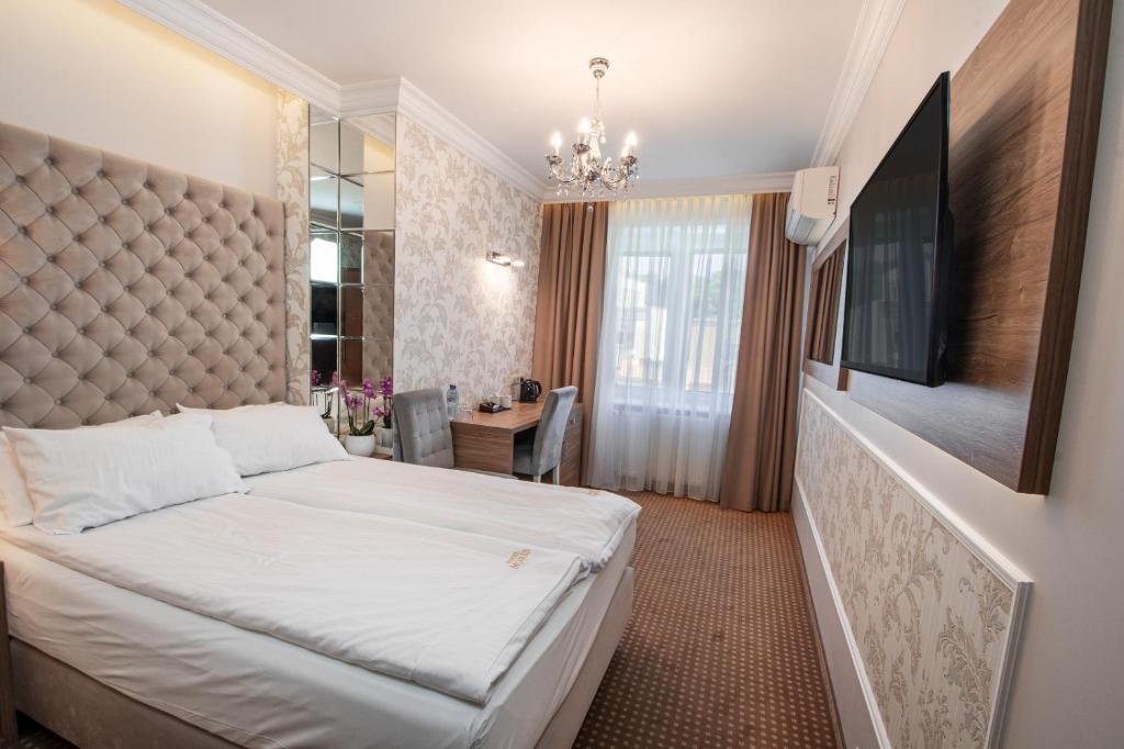 a hotel room with a bed and a tv at Moris Boutique Beach Hotel in Gdańsk