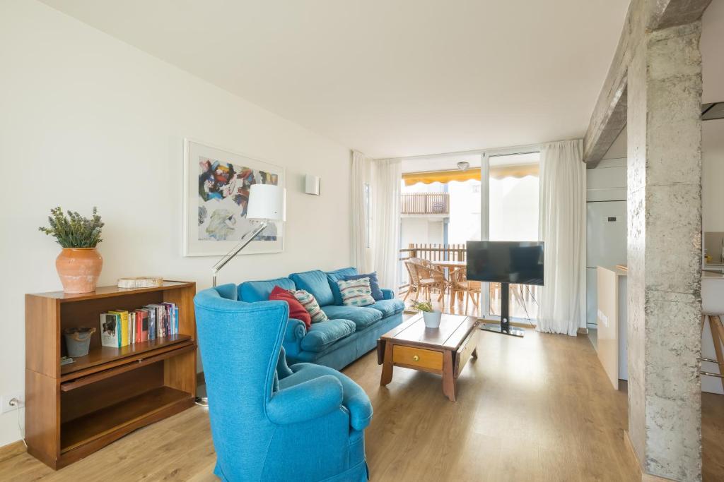 a living room with a blue couch and a tv at Fantastic beach apartment near Valencia in Valencia