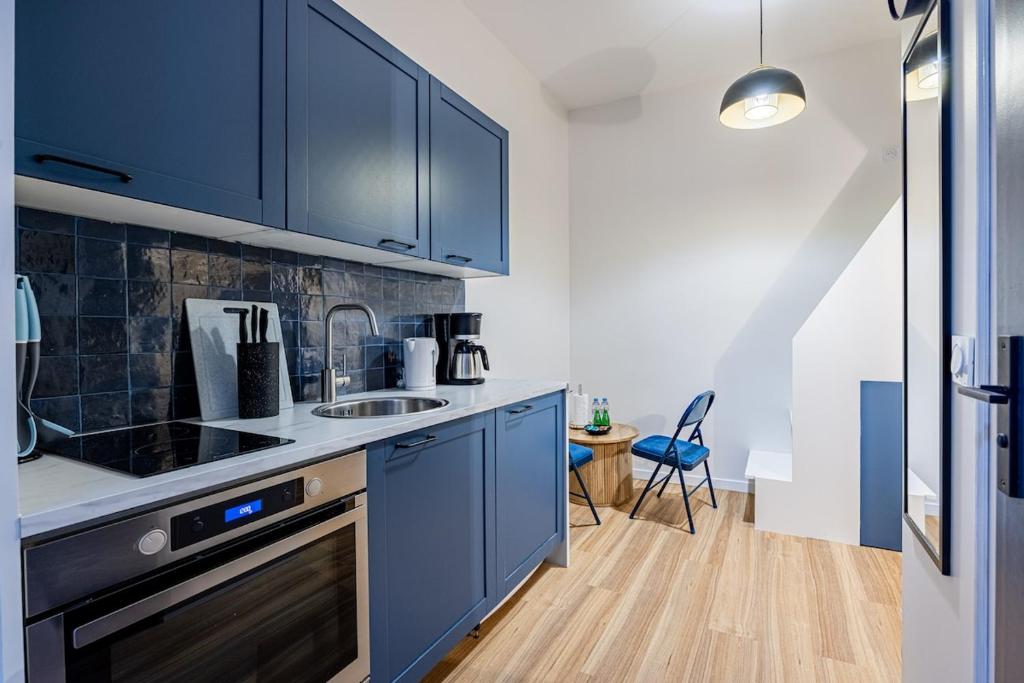 une cuisine avec des armoires bleues et un évier dans l'établissement 2#Cosy studio#Paris13#JardindesPlantes, à Paris