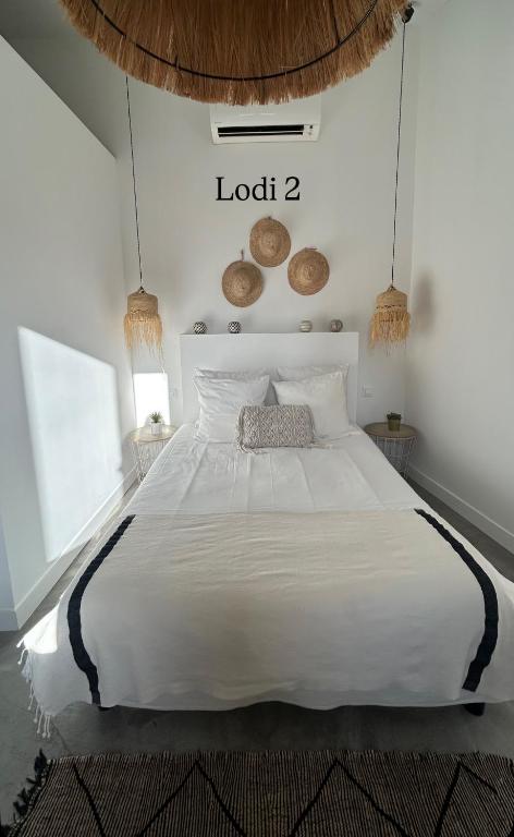 une chambre avec un grand lit blanc dans une pièce dans l'établissement Le Lodi, à Marseille