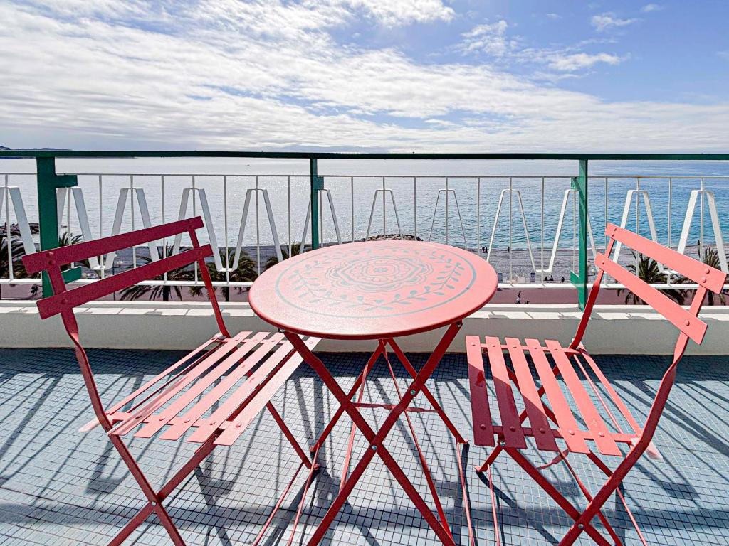 une table et deux chaises assises sur un balcon dans l'établissement Promenade des Anglais - Vue Mer, AC, 2pers, à Nice