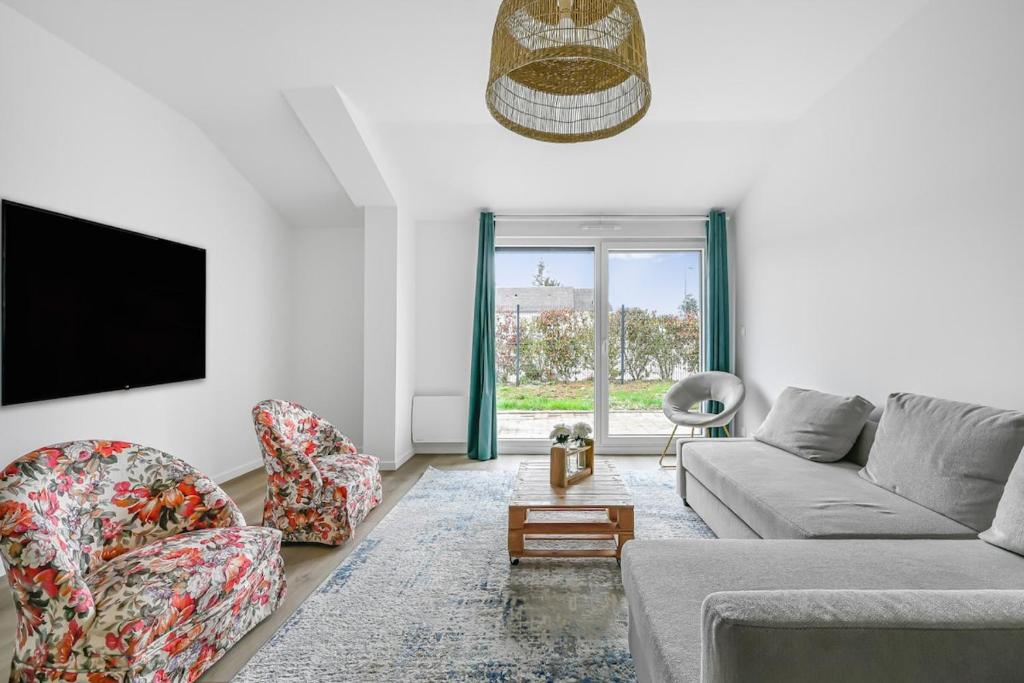 un salon avec un canapé, des chaises et une télévision dans l'établissement La Douce Escapade - 6 pers - Jardin - Wifi, à Évreux