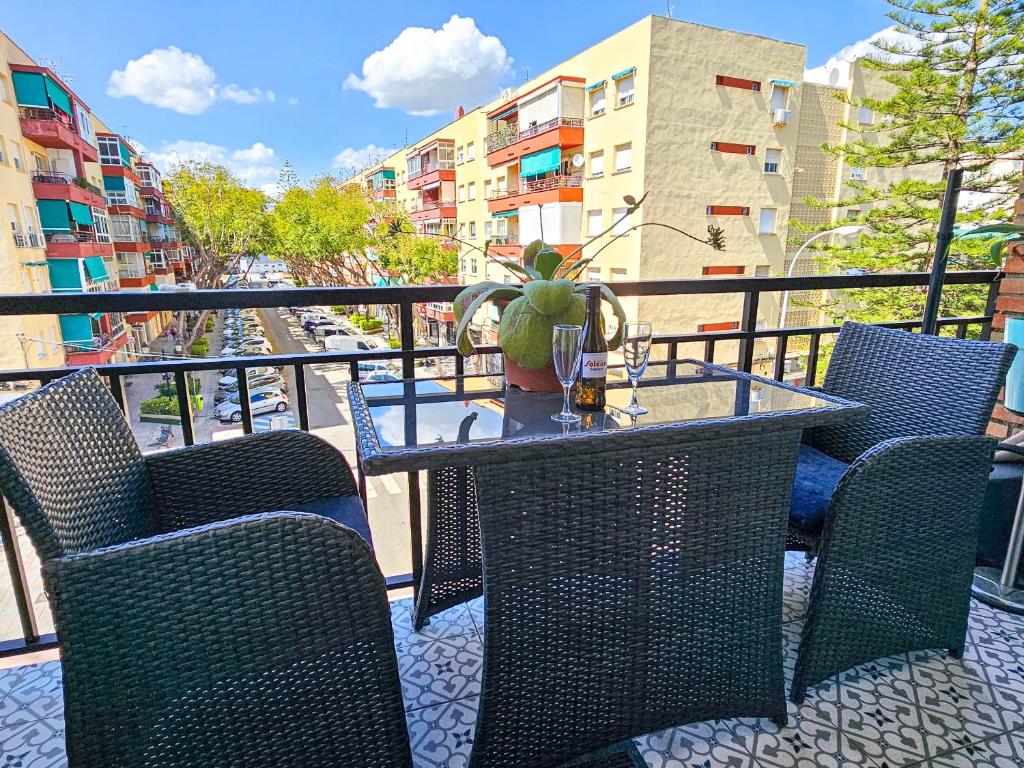 ein Tisch mit Stühlen und einer Vase auf einem Balkon in der Unterkunft One bedroom apartment central Fuengirola in Santa Fe de los Boliches