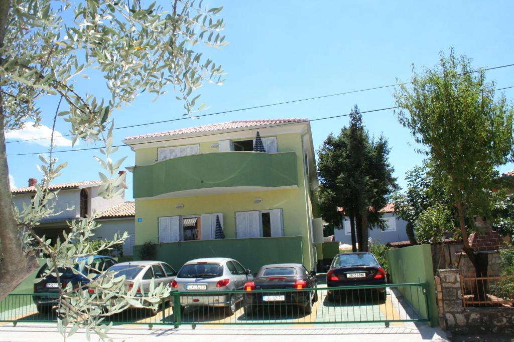 un grupo de autos estacionados frente a una casa en Villa Victory, en Umag