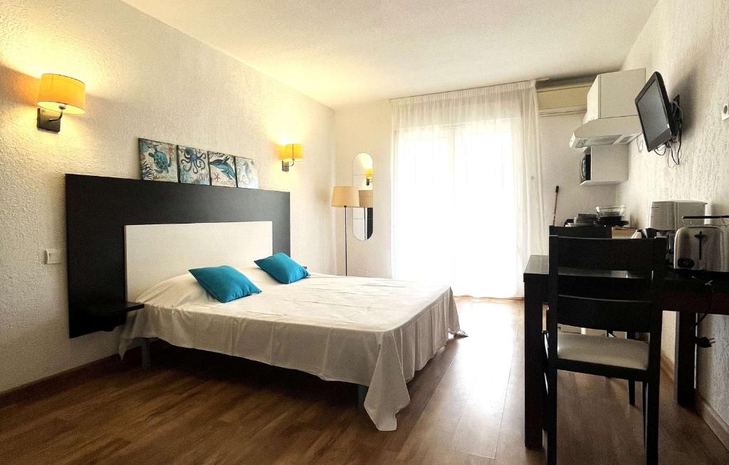 ein Schlafzimmer mit einem Bett mit blauen Kissen darauf in der Unterkunft Studio 3 pers climatisé avec piscine à ST FLORENT in Saint-Florent