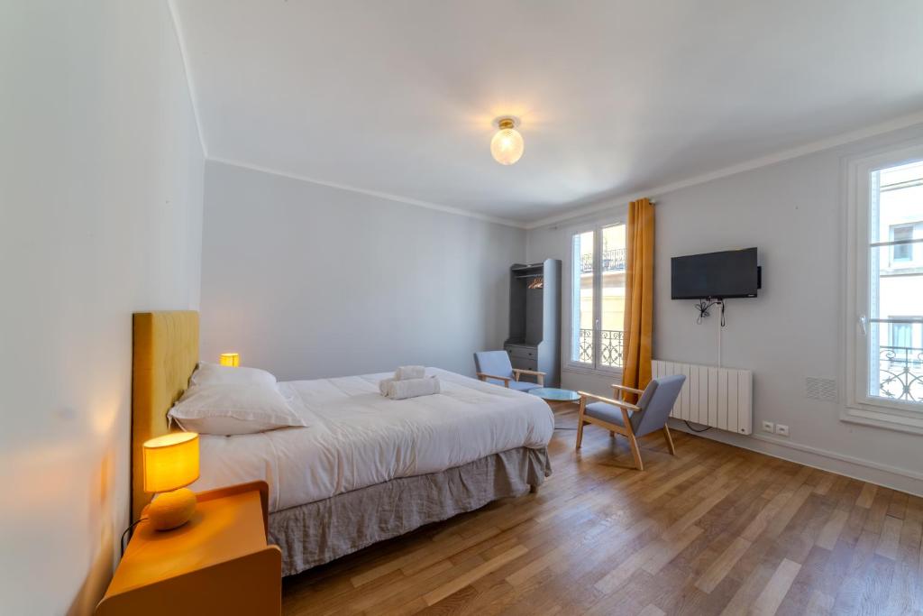 une chambre d'hôtel avec un lit et une télévision dans l'établissement Majestic Suite, à Paris