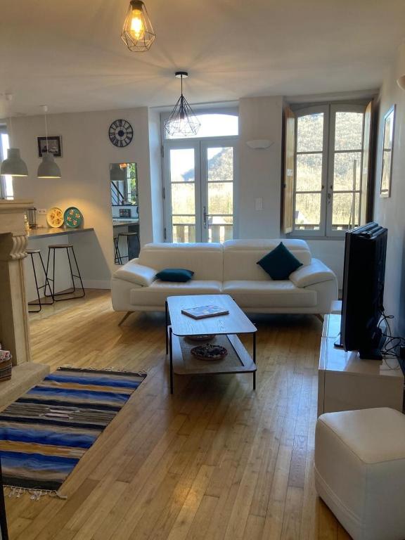 un salon avec un canapé blanc et une table dans l'établissement Duplex-Au château ambulant-au bord de la Dordogne, à Castelnaud-la-Chapelle