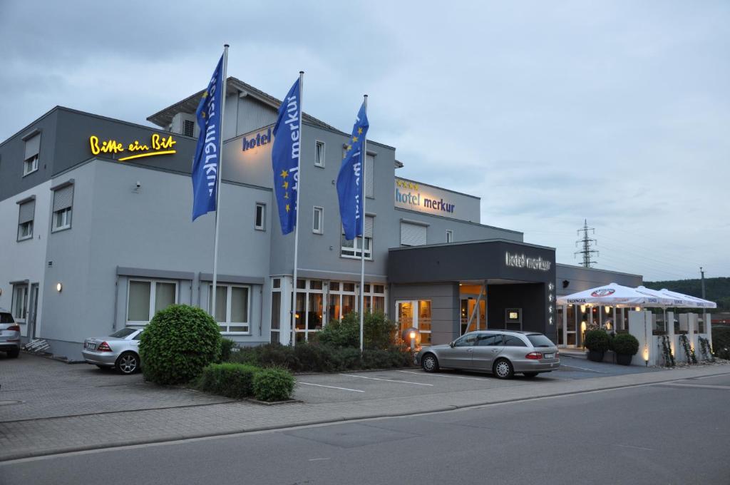 ein Hotel mit davor geparkt in der Unterkunft Hotel Merkur in Landstuhl