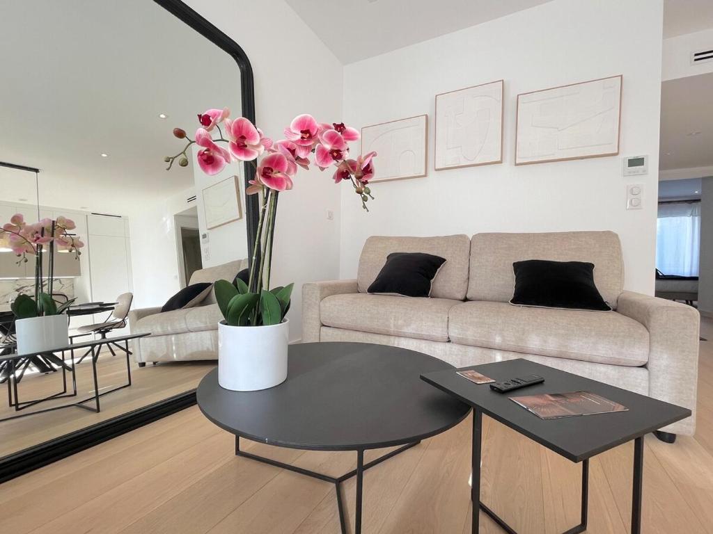 - un salon avec un canapé et une table ornée de fleurs roses dans l'établissement 3 Rooms wifi parking center, à Cannes