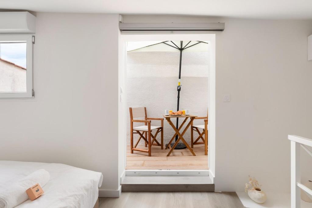 - une chambre avec une porte menant à une salle à manger avec une table dans l'établissement Suquet Lovers- centre historique, à Cannes