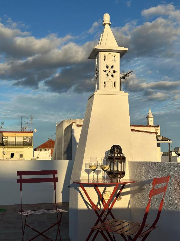 una mesa con una torre de reloj en la parte superior de un edificio en Casa Dar Alma, en Vila Real de Santo António