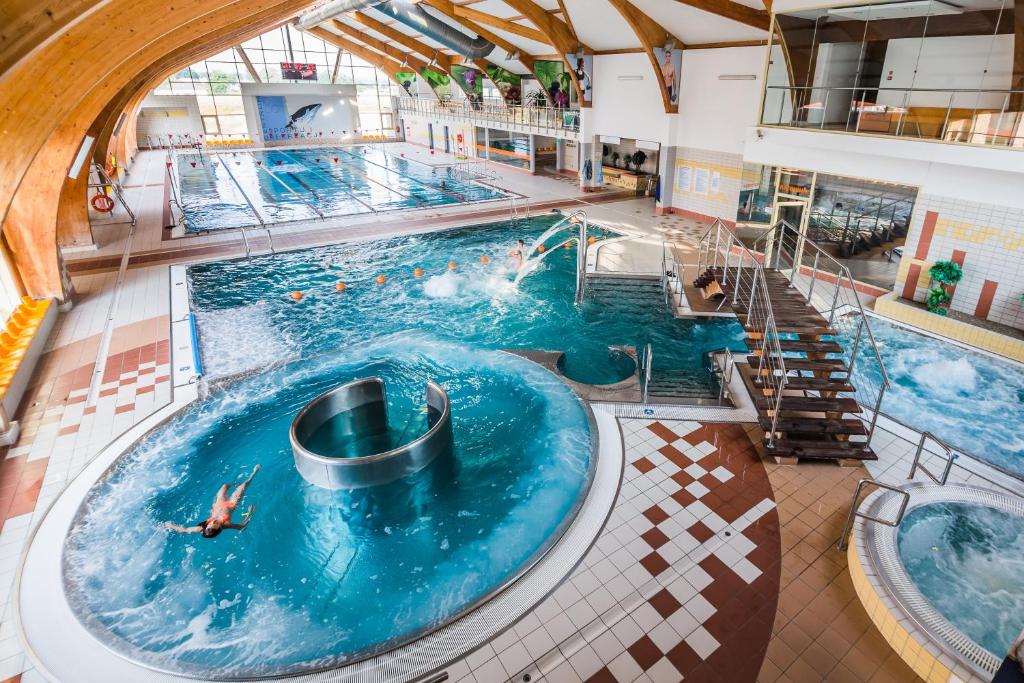 an overhead view of a swimming pool with people in it at Hotel i Aquapark Olender in Toruń