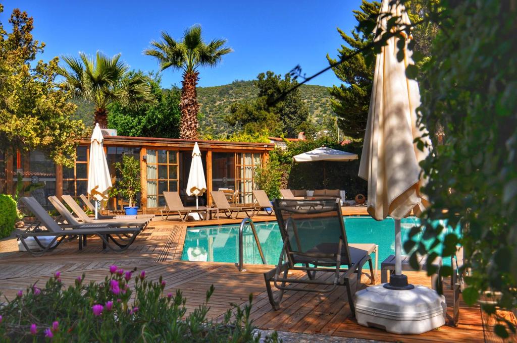 a swimming pool with chairs and umbrellas next to a swimming pool at Costa Bodrum City in Bodrum City