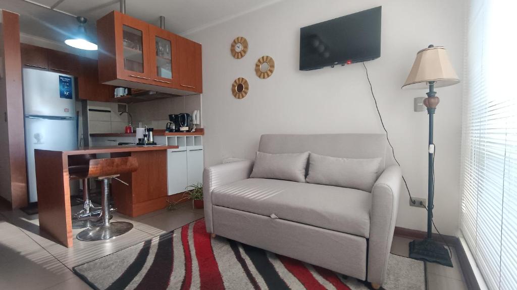 Una sala de estar con un sofá y una cocina. en DSalas 445 con estacionamiento Concepcion, en Concepción