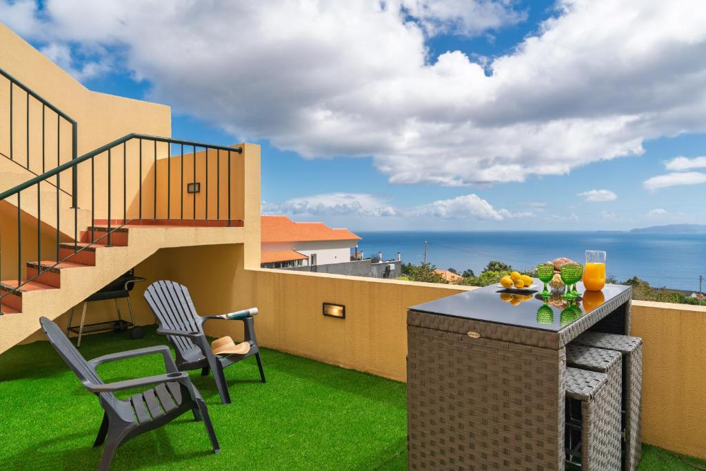 a balcony with a table and chairs and a staircase at Strategic Sunset House by An Island Apart in Santa Cruz
