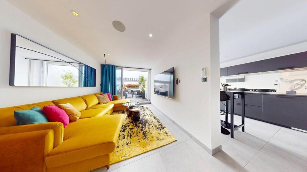 un salon avec un canapé jaune et une cuisine dans l'établissement Le Majestic, Naturist Village 3 bedrooms 90 m2, au Cap d'Agde