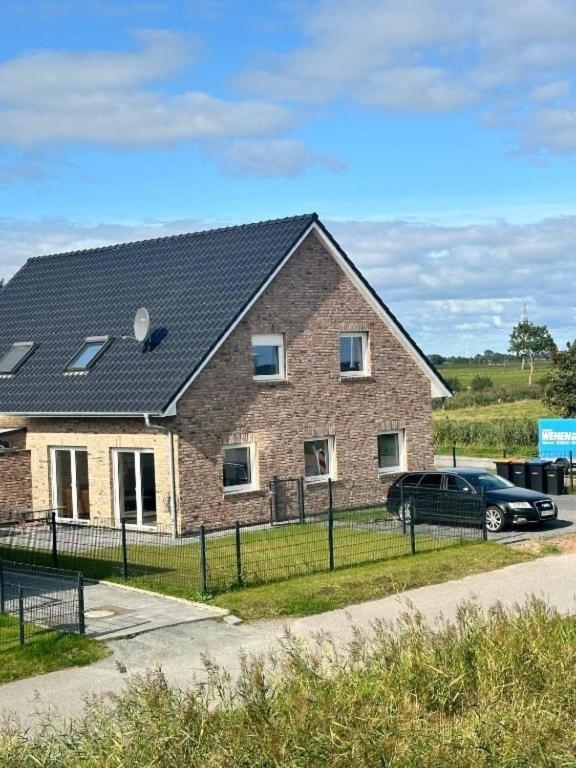a house with a car parked in front of it at Wangermeerglück in Wangerland