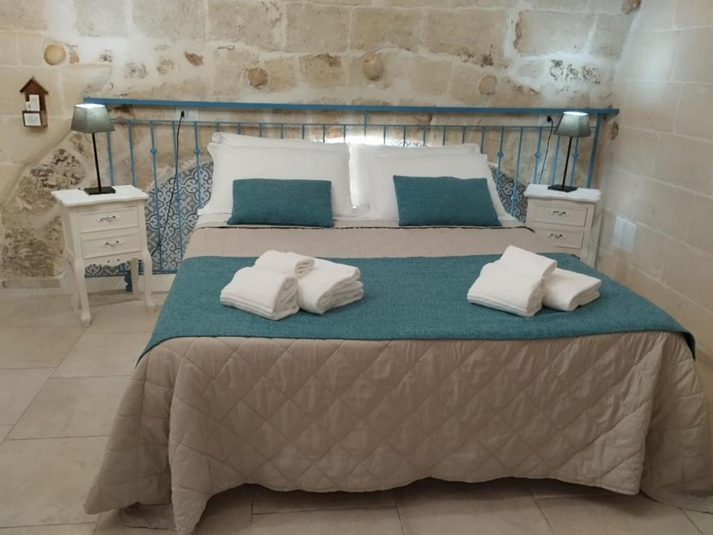 een slaapkamer met een bed met twee kussens erop bij Dimora Don Camillo in Monopoli