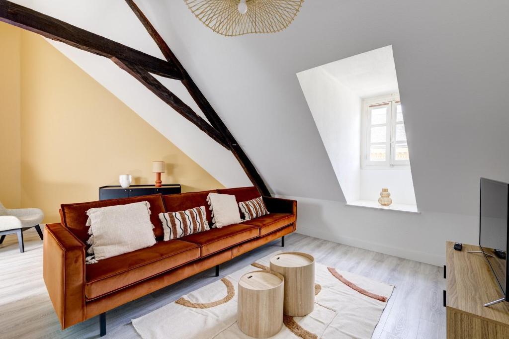 un salon avec un canapé marron et des tabourets en bois dans l'établissement OIQIA • Hesperis, à Sarlat-la-Canéda