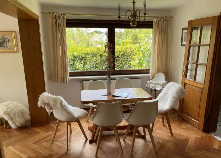 a dining room with a table and chairs and a window at Landhaus Eva-Maria in Elbingerode