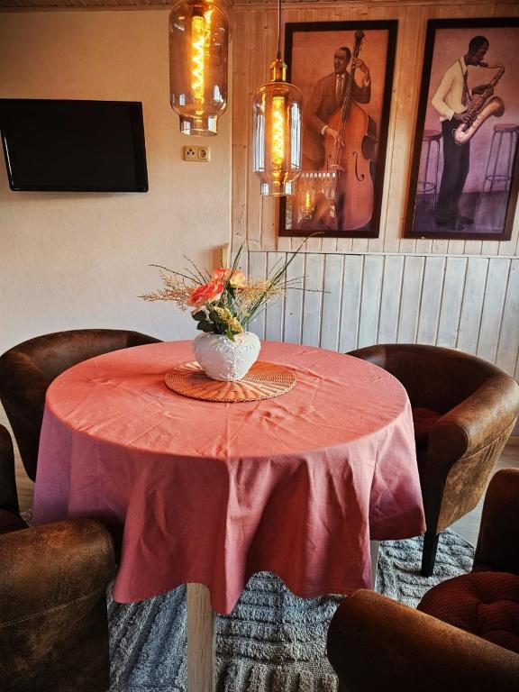 a red table with a vase of flowers on it at FeWo Cuba in Neue Scheune