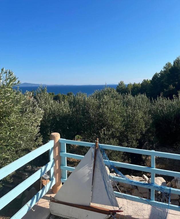 a bench on a fence with the ocean in the background at Kolonjicha Dvori in Ivan Dolac