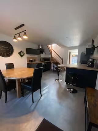 une pièce avec une table et des chaises et une cuisine dans l'établissement La Risloise, à Pont-Audemer