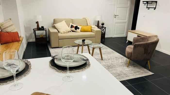 ein Wohnzimmer mit einem Tisch und Weingläsern darauf in der Unterkunft Casa da Marina in Angra do Heroísmo