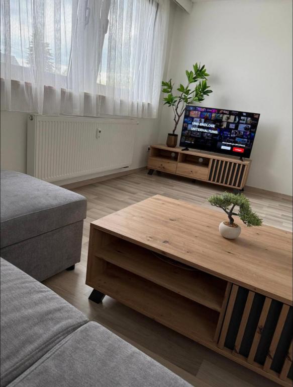 a living room with a coffee table and a flat screen tv at Dachtraum Sahin in Günzburg