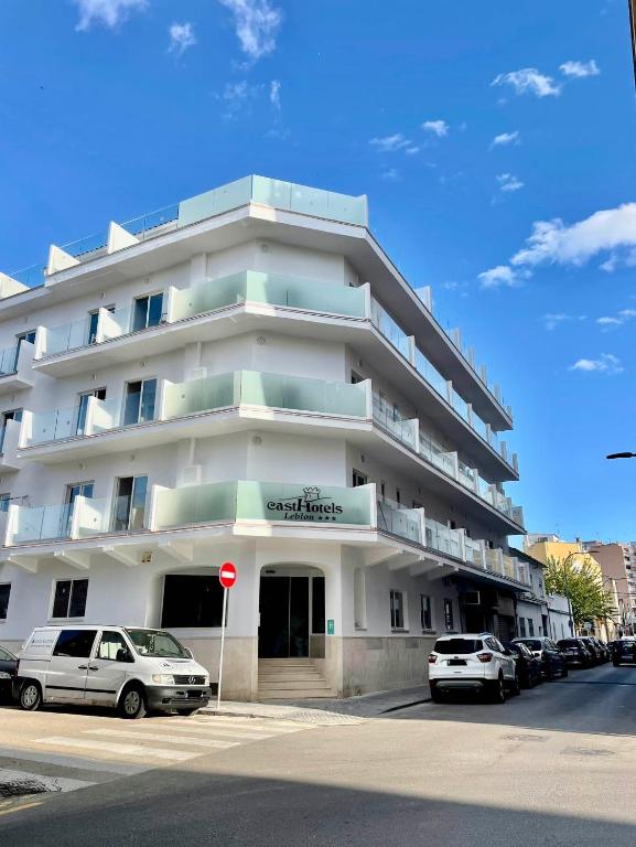 a white building with cars parked in front of it at Casthotels Leblon in El Arenal