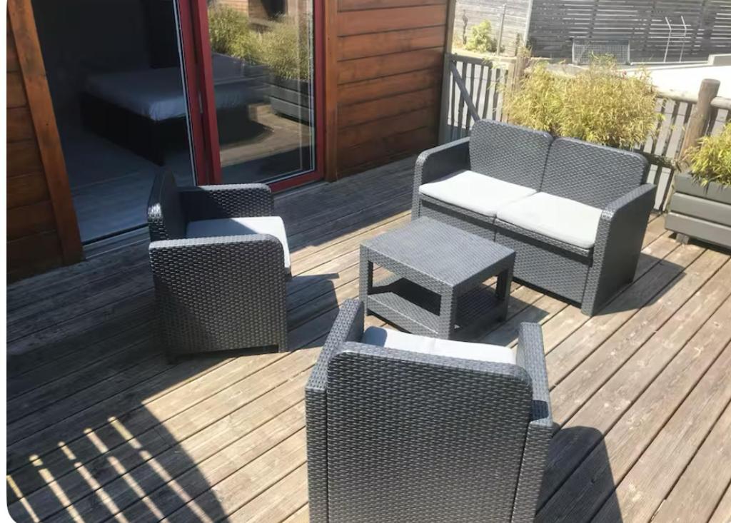 un patio avec deux chaises et une table sur une terrasse dans l'établissement Chalet bois, à Kervic
