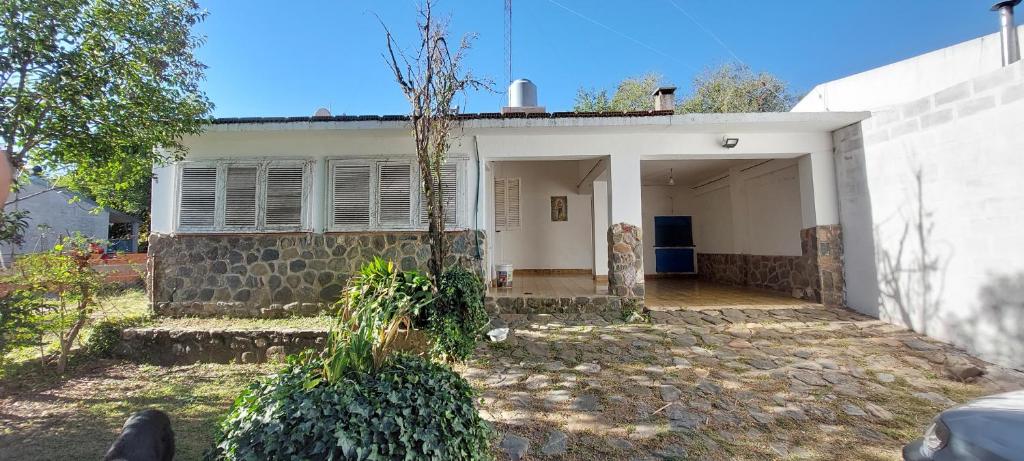 a white house with a tree in front of it at Casa en el Río in Alpa Corral