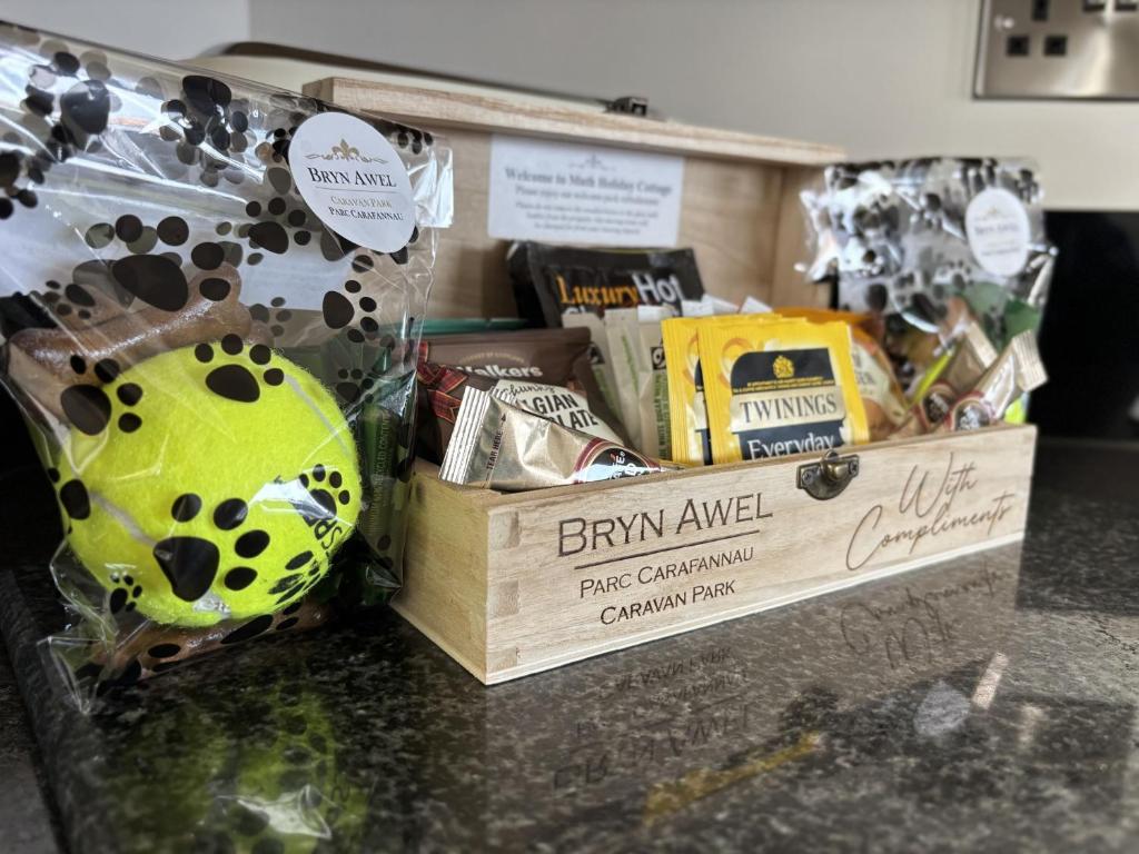 a counter with a box of food and a toy at Math Holiday Cottage in Pentraeth