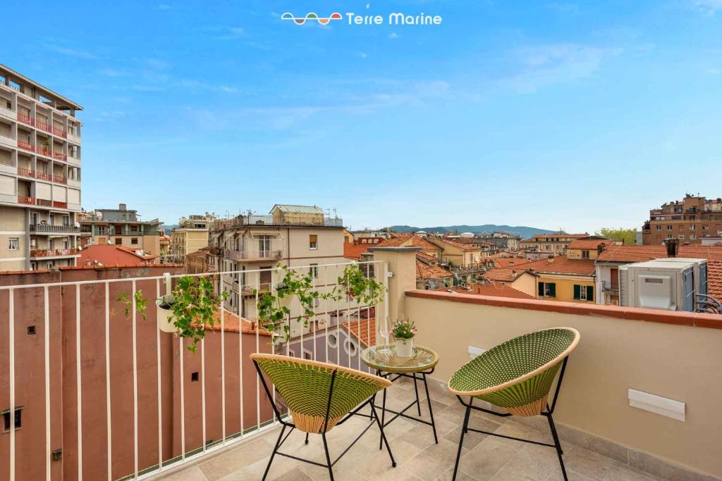 a patio with two chairs and a table on a balcony at Le Dimore dei Fiori, Terre Marine in La Spezia