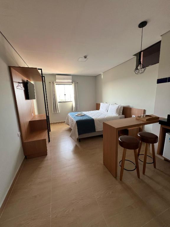 a hotel room with a bed and a desk and a desk at Barra Hotel in Vargem Grande do Sul