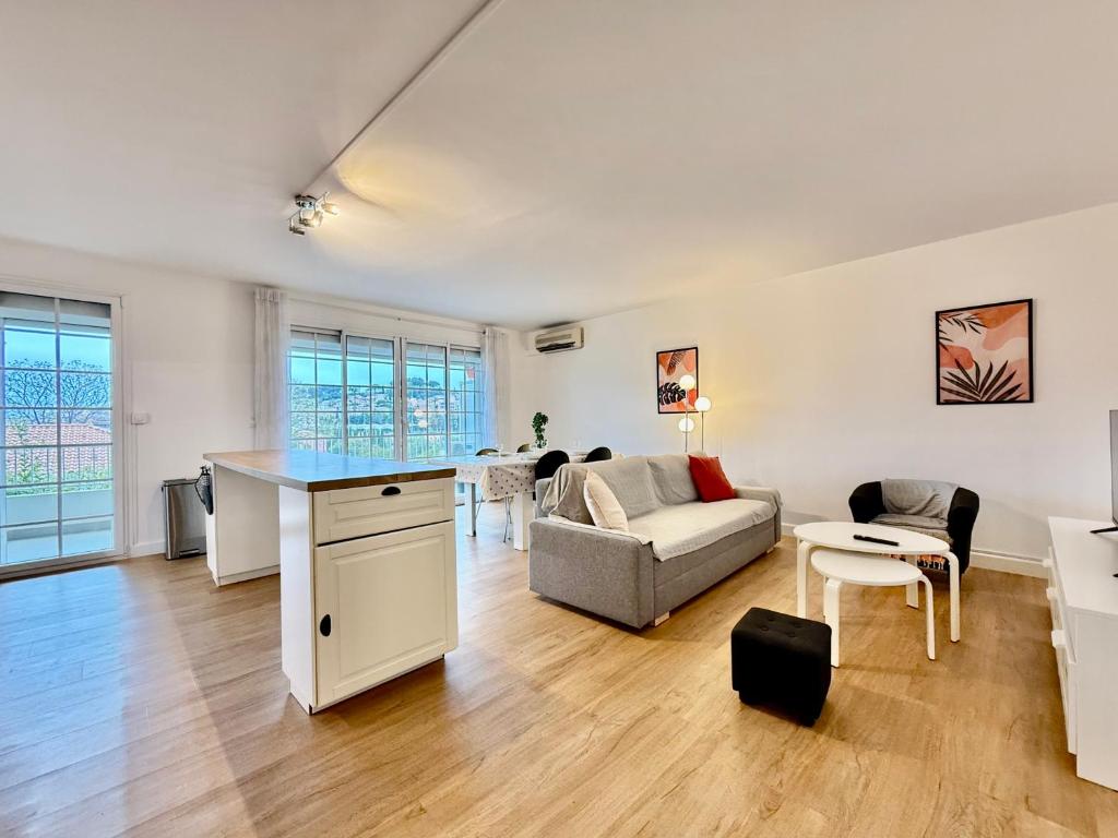 une cuisine et un salon avec un canapé et une table dans l'établissement Moderne - Terrasse - Proche plages, à Carqueiranne