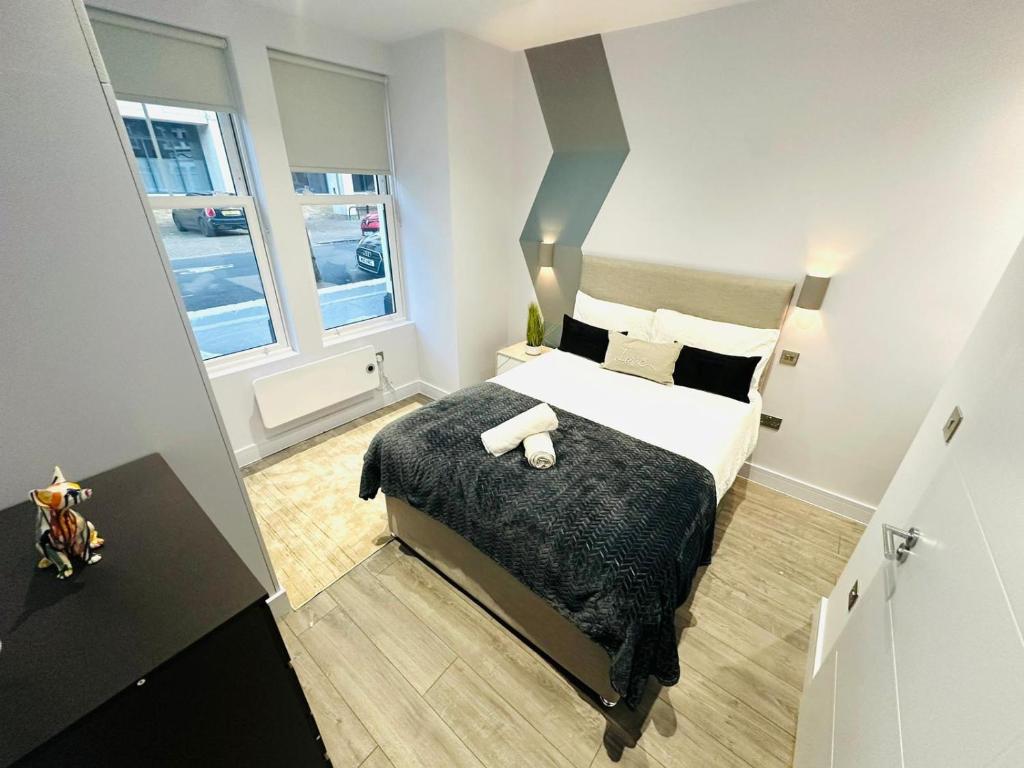 a bedroom with a large bed and two windows at Wandsworth House - NO 17 - Luxury Urban Rooms in London