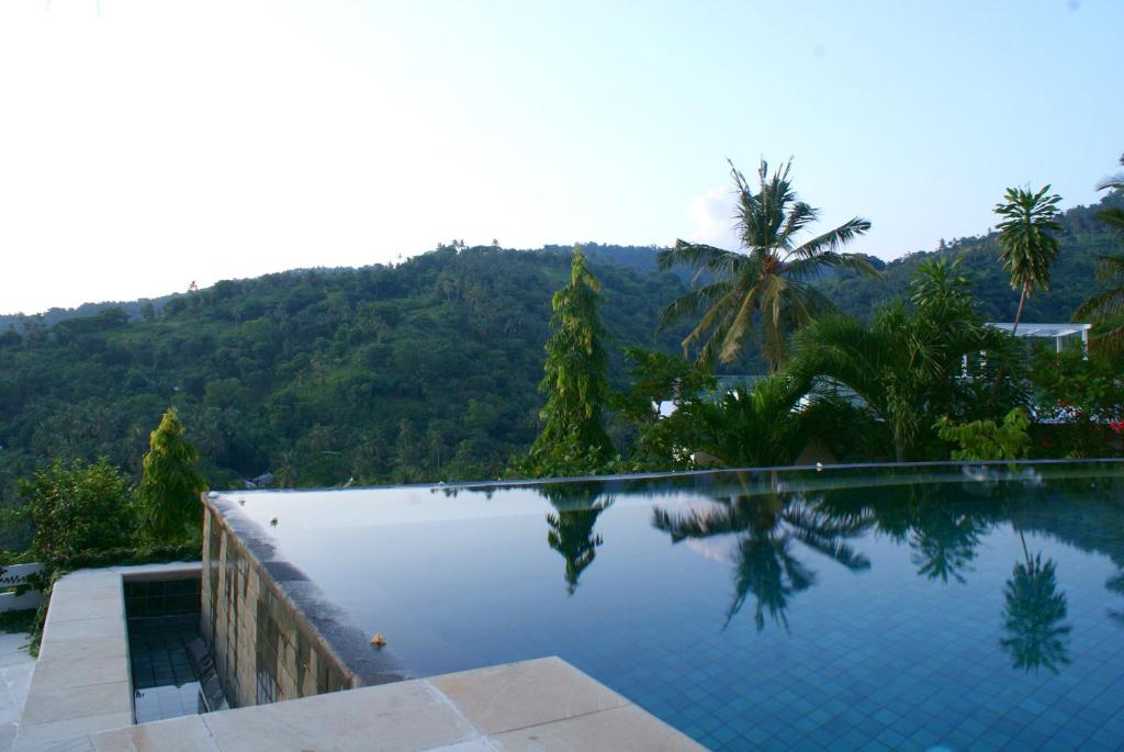 a swimming pool with a mountain in the background at Villa Buah in Senggigi 