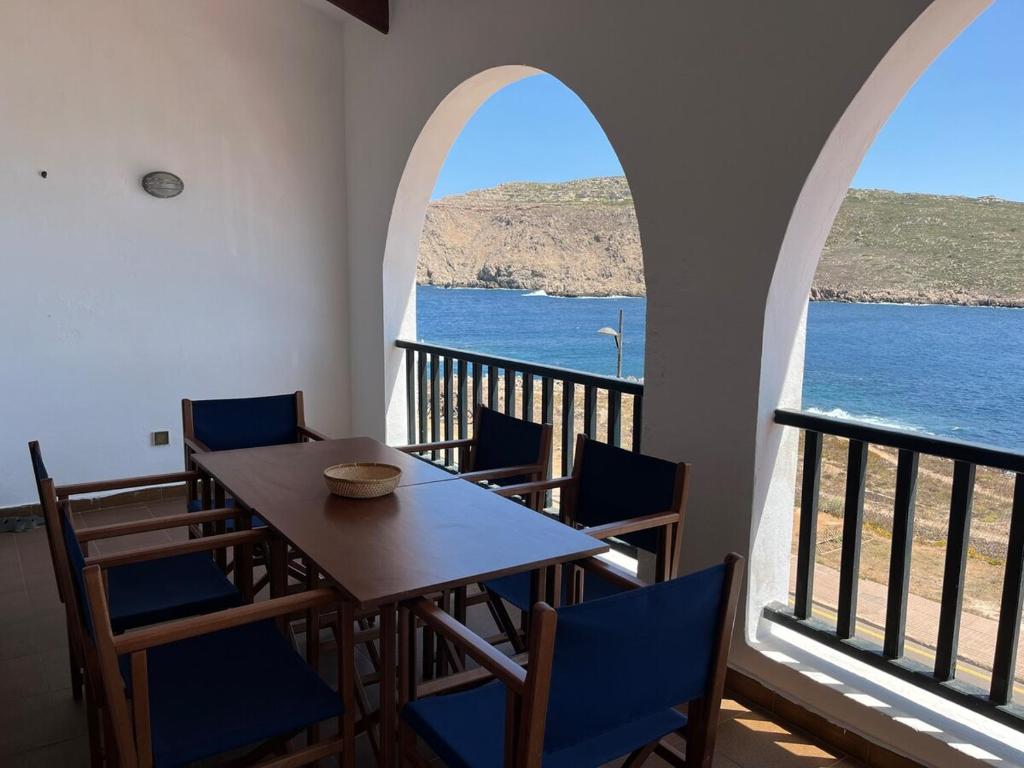 ein Tisch und Stühle mit Blick auf das Wasser in der Unterkunft ES FAR AZUL by SOM Menorca in Fornells