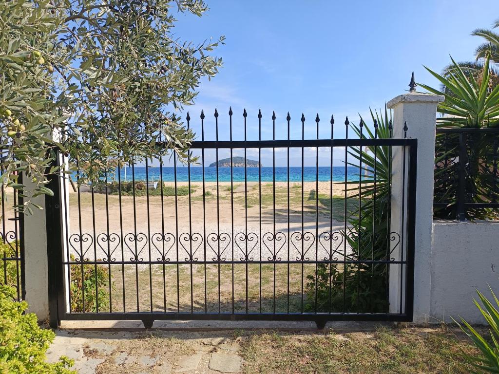 an iron gate with a view of the beach at beach house Blue Sea in Iraklitsa