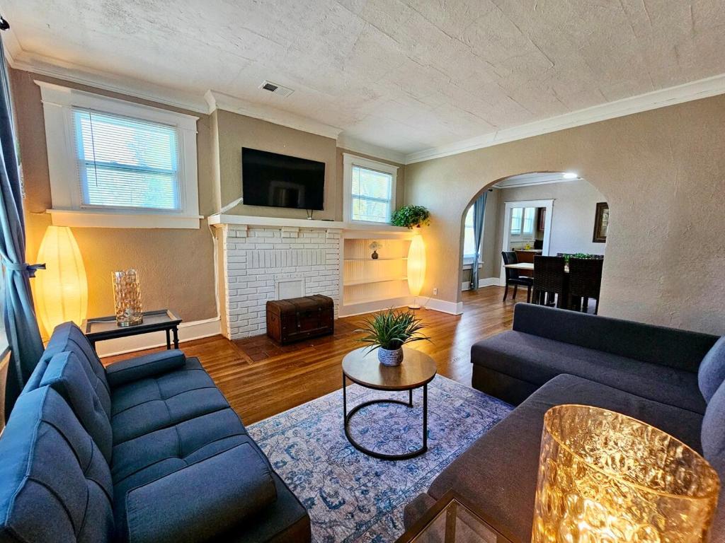 a living room with two blue couches and a fireplace at Charming house in Memphis in Memphis