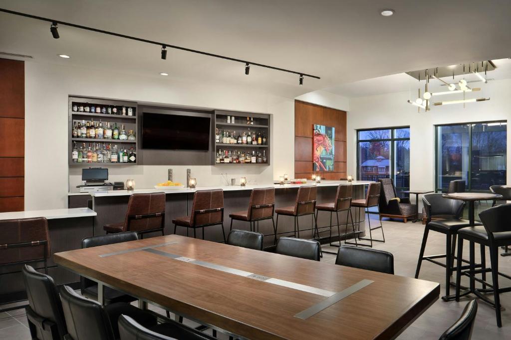 a bar in a restaurant with a table and chairs at Courtyard by Marriott Saratoga Springs in Saratoga Springs