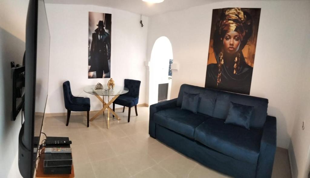 a living room with a black couch and a table at Nid Douillet in Neuilly-sur-Marne