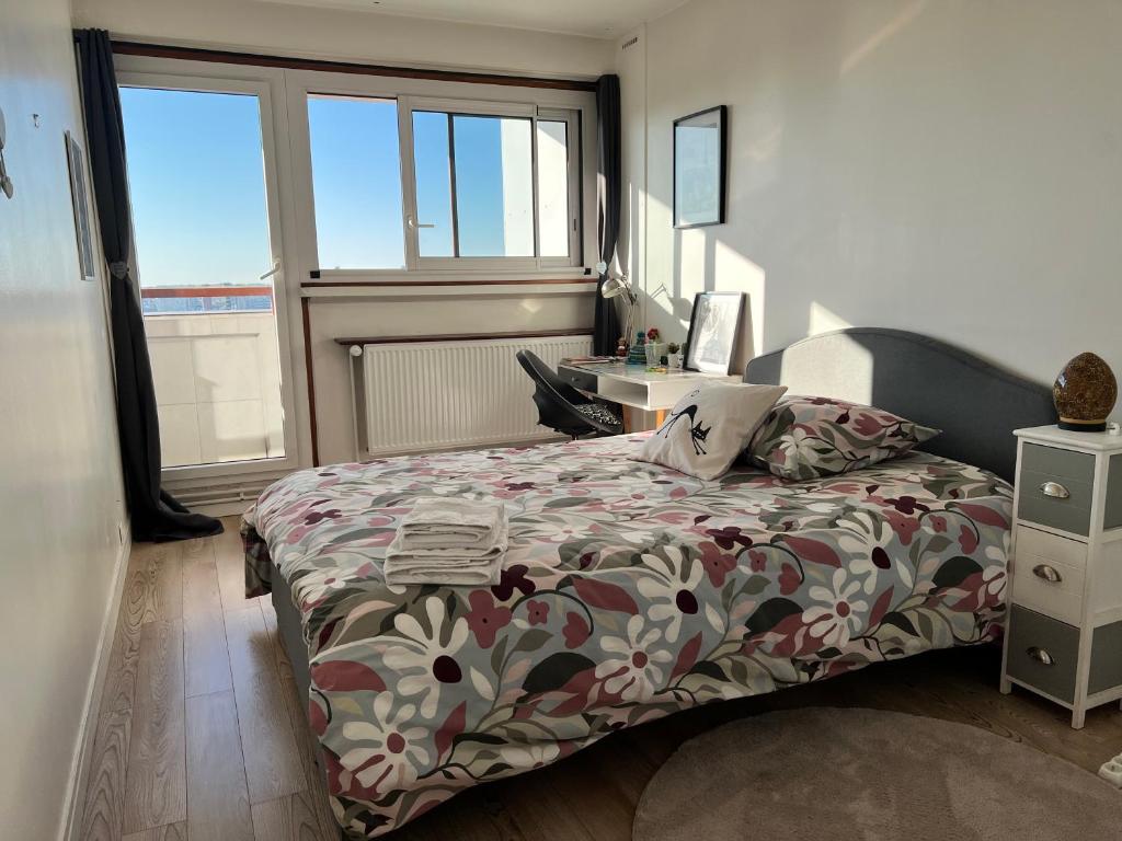 une chambre avec un lit, un bureau et des fenêtres dans l'établissement Quarto Privado em Apartamento Vista Torre Eiffel, à Paris