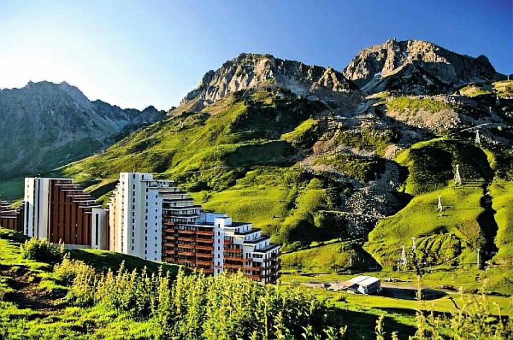 un bâtiment sur une colline avec une montagne dans l'établissement Résidence Le Montana - maeva Home - Studio 4 personnes - Sélection MAE-0661, à La Mongie