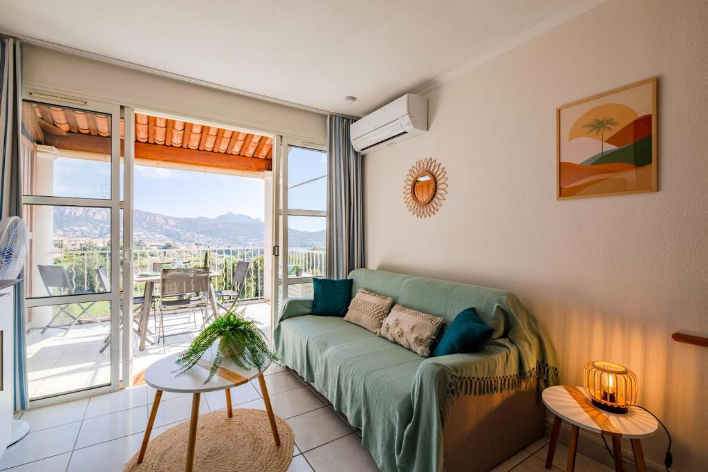 un salon avec un canapé et une grande fenêtre dans l'établissement Résidence le Hameau de Cap Esterel - maeva Home - Appartement vue mer 2 pièces 4 personnes - Prestige - super Home MAE-1861, à Saint-Raphaël